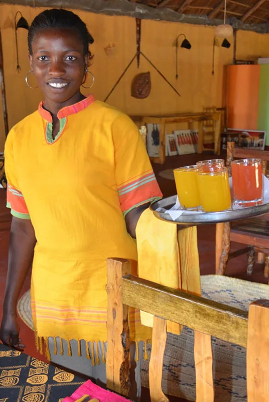 A member of the Nsya Lodge team carrying welcome drinks